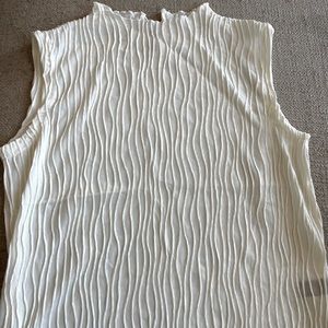 Sleeveless off white top.